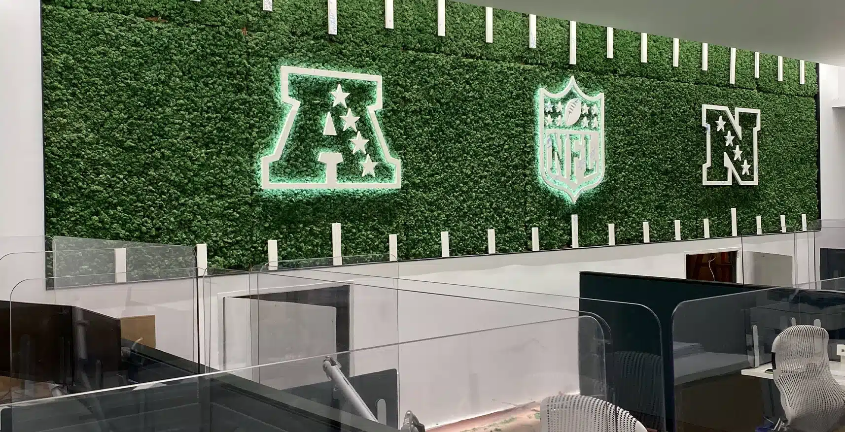 Bevarad grön vägginstallation i ett professionellt arbetsutrymme - akustisk behandling integrerad i inredningen